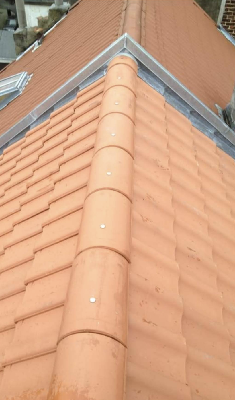 Détail de faîtage en tuiles terre cuite avec finitions zinc