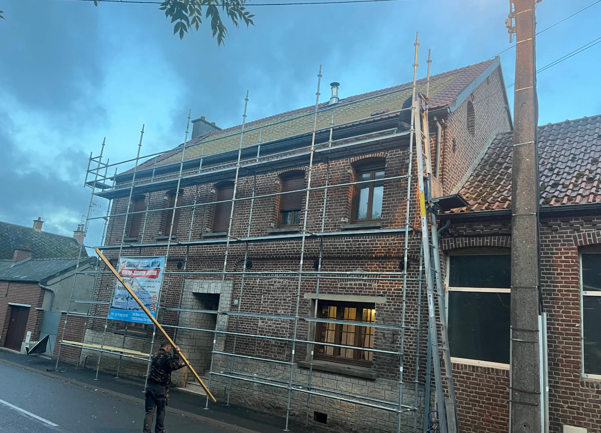 Rénovation de toiture en tuiles sur maison en briques avec échafaudage