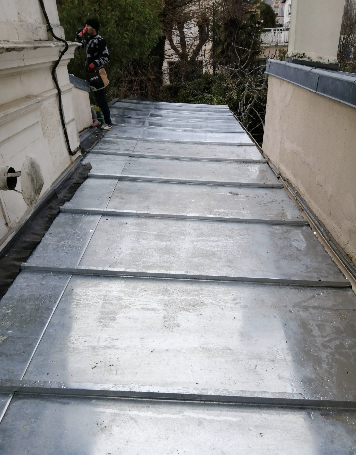 Toiture en zinc réalisée entre deux murs avec finitions soignées