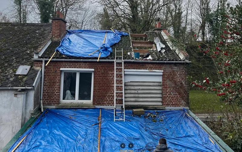 Chantier de rénovation de toiture en cours avec bâches de protection